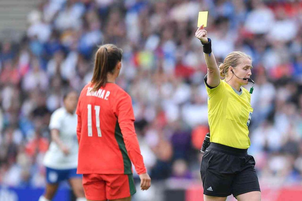 Arbitro donna estrae cartellino in partita di calcio femminile