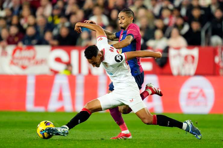 Intervento in scivolata di un calciatore del Siviglia