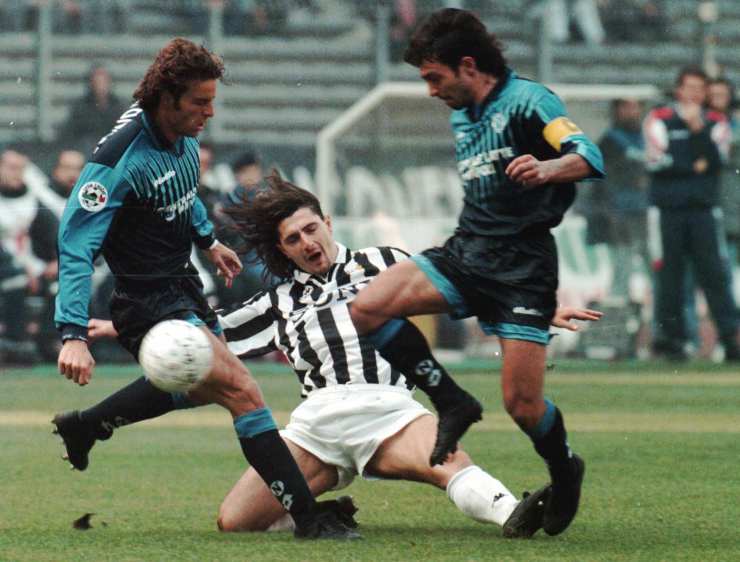 padovano contrasta due avversari in scivolata